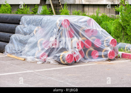 Pila di tubi neri avvolti in plastica Foto Stock