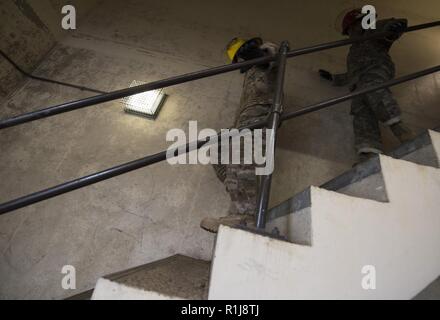Avieri dal 422delle forze di sicurezza Squadron manovra verso il basso una serie di scale durante un vigile del fuoco sfida a RAF Croughton, Inghilterra il 5 ottobre, 2018. La sfida era parte del kick off evento per la prevenzione degli incendi settimana che si verifica ogni anno nel mese di ottobre in uno sforzo per informare la comunità sulla sicurezza antincendio e prevenzione. Foto Stock
