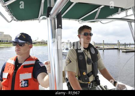 Coast Guard Petty Officer 2a classe Timoteo vinello, una scienza marina tecnico assegnato al settore di Boston, e Tyler Ingle, un senior officer presso la North Carolina Wildlife risorse Commissione, approccio una barca a vela affondata sul fiume Trent, New Bern, N.C., domenica 7 ottobre, 2018. La Guardia Costiera ha collaborato con la Carolina del Nord la fauna selvatica delle risorse la Commissione e gli Stati Uniti Agenzia per la protezione ambientale sotto un comando unificato per effettuare il supporto di emergenza funzione-10 di missione che ha agito per ridurre al minimo i danni ambientali dopo l uragano Firenze. Foto Stock