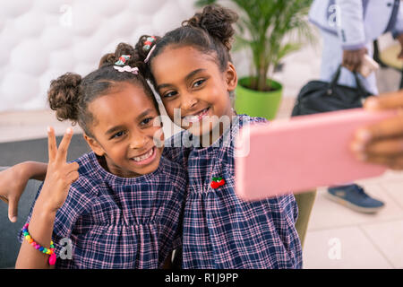 Trasmissione via IR di moderna bambini rendendo selfie mentre è seduto nella caffetteria Foto Stock