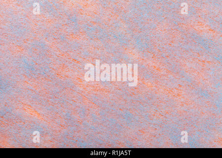 Costruzione di una luce blu con sfondo oranje macchie di tessuto di feltro closeup. Tessitura di lana tessuto opaco. Panno sullo sfondo. Foto Stock