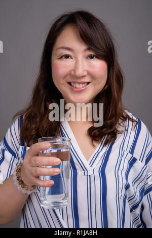 Coppia bella asiatica imprenditrice tenendo un bicchiere di acqua Foto Stock