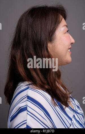 Vista di profilo di coppia bella asiatica imprenditrice sorridente Foto Stock