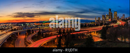 Panorama di Seattle Downtown skyline al di là della I-5 I-90 Interscambio superstrada al tramonto con esposizione a lungo il sentiero del traffico luci dal Dott. Jose Rizal o Foto Stock