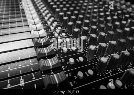 Basso livello di vista i fader su un Audio Professionale Console di miscelazione al festival di musica, scrivania nero e bianco i fader Foto Stock