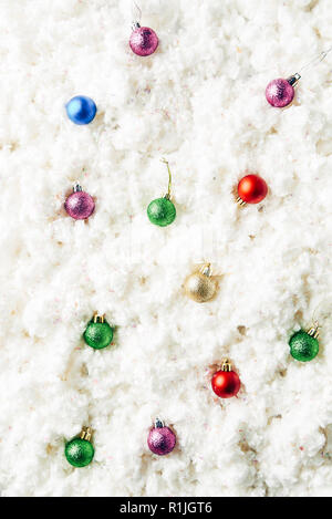 Vista dall'alto di coloratissimi giocattoli di Natale sul cotone bianco sullo sfondo di lana Foto Stock