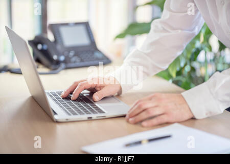 Uomo d affari con computer laptop sulla scrivania in ufficio Foto Stock