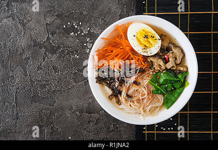La dieta vegetariana ciotola di zuppa di spaghetti di funghi shiitake, carota e uova sode. Il cibo giapponese. Vista dall'alto. Lay piatto Foto Stock