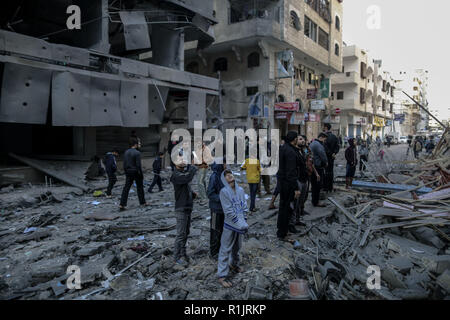 La striscia di Gaza, Territori palestinesi. Xiii Nov, 2018. Palestinesi ispezionare il danno di un distrutto edificio residenziale dopo aver colpito dalle incursioni aeree israeliane. Credito: Mohammed Talatene/dpa/Alamy Live News Foto Stock