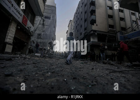 La striscia di Gaza, Territori palestinesi. Xiii Nov, 2018. Palestinesi ispezionare il danno di un distrutto edificio residenziale dopo aver colpito dalle incursioni aeree israeliane. Credito: Mohammed Talatene/dpa/Alamy Live News Foto Stock