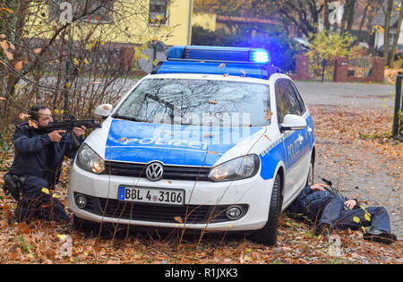 13 novembre 2018, Brandeburgo, Bernau: durante un anti-terrorismo di esercizio, un poliziotto gli obiettivi con la sua pistola mentre un altro poliziotto è disteso sul terreno. Per la prima volta in questa dimensione, il quartier generale della polizia effettuerà una due giorni di pieno esercizio su un attacco terroristico scenario. L' esercizio " Atto 2018' (azione contro il terrore 2018) si concentra su un attacco multiplo scenario con diverse posizioni di esercizio. Lo scopo di questo esercizio è esaminare i concetti funzionali redatto e l'interazione di tutte le unità di polizia coinvolti e di trarre conclusioni per ulteriori misure se necessario. Foto: Foto Stock