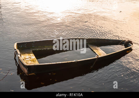 Balloch, Scotland, Regno Unito. 13 Novembre, 2018. Regno Unito Meteo. Una piccola barca a remi parzialmente sommerso sul fiume Leven durante il sole e docce in un pomeriggio freddo nella città di Balloch sulla sponda meridionale del Loch Lomond. Credito: Berretto Alamy/Live News Foto Stock