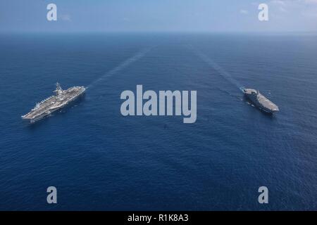 Mare delle Filippine (ott. 9, 2018) Il Nimitz-class portaerei USS Ronald Reagan (CVN 76) e il Giappone marittimo Forza di Autodifesa elicottero destroyer JS Izumo (DDH 183) sono in corso di svolgimento a fianco di ogni altro durante una cooperativa di distribuzione. Ronald Reagan è distribuita negli Stati Uniti 7 flotta area di operazioni a sostegno della sicurezza e della stabilità nella regione Indo-Pacifico. Foto Stock