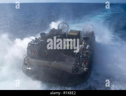 Oceano Pacifico (ott. 10, 2018) Landing Craft Air Cushion (LCAC) 76, assegnato all assalto unità artigianali (ACU) 5, approda ben coperta dell'assalto anfibio nave USS Bonhomme Richard (LHD 6). Bonhomme Richard è operante negli Stati Uniti La terza area della flotta di operazioni. Foto Stock