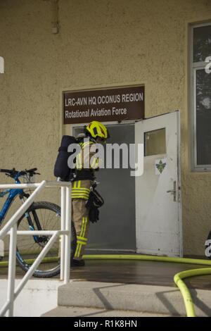 Stati Uniti Esercito vigili del fuoco civili dalla U.S. Army Garrison (USAG) Ansbach dimostrare evacuazione e salvataggio procedure al battaglione e quartier generale di brigata a Storck Baracks in Illesheim, Germania, 10 ottobre, 2018. La dimostrazione è parte del presidio di ricorrenza annuale per la prevenzione degli incendi e per la settimana. Foto Stock