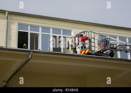 Stati Uniti Esercito vigili del fuoco civili dalla U.S. Army Garrison (USAG) Ansbach dimostrare evacuazione e salvataggio procedure al battaglione e quartier generale di brigata a Storck Baracks in Illesheim, Germania, 10 ottobre, 2018. La dimostrazione è parte del presidio di ricorrenza annuale per la prevenzione degli incendi e per la settimana. Foto Stock