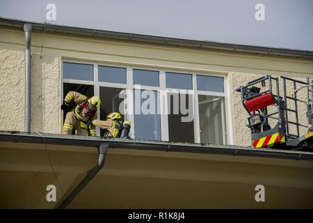 Stati Uniti Esercito vigili del fuoco civili dalla U.S. Army Garrison (USAG) Ansbach dimostrare evacuazione e salvataggio procedure al battaglione e quartier generale di brigata a Storck Baracks in Illesheim, Germania, 10 ottobre, 2018. La dimostrazione è parte del presidio di ricorrenza annuale per la prevenzione degli incendi e per la settimana. Foto Stock