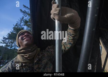 Stati Uniti Marine Corps Lance Cpl. Romero Boyd con sede reggimento, 2° Marine Logistics Group in avanti, fino al lato di un riparo durante la costruzione della seconda MLG in avanti il comando del centro di funzionamento per Trident frangente 18 in Norvegia, il 7 ottobre 2018. Trident frangente 18 è parte di un esercizio pianificato serie per migliorare gli Stati Uniti e gli alleati della NATO la loro capacità di lavorare insieme collettivamente a condurre operazioni militari sotto condizioni impegnative. Foto Stock