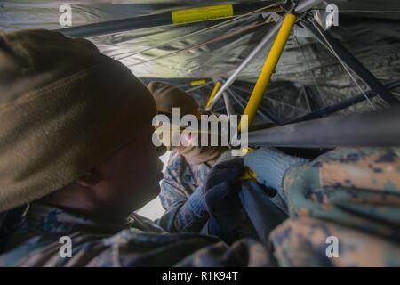 Stati Uniti Marine Corps Lance Cpl. Shakia Wilson, sinistra e Cpl. Dean Phillips con sede reggimento, 2° Marine Logistics Group in avanti, attaccare una tenda la camicia per un rifugio durante la costruzione della seconda MLG in avanti il comando del centro di funzionamento per Trident frangente 18 in Norvegia, il 7 ottobre 2018. Trident frangente 18 è parte di un esercizio pianificato serie per migliorare gli Stati Uniti e gli alleati della NATO la loro capacità di lavorare insieme collettivamente a condurre operazioni militari sotto condizioni impegnative. Foto Stock