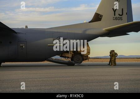 Stati Uniti I soldati dell esercito assegnato al XVIII Campo brigata di artiglieria caricare un M142 High Mobility Artillery Rocket System (HIMARS) in un 374 Airlift Wing C-130 Hercules sulla linea di volo a Fort Greely, Alaska, il 9 ottobre 2018, durante la bandiera rossa-Alaska 19-1. Quando si collabora insieme, la C-130 Hercules e M142 HIMARS diventano una precisione sciopero strategica pacchetto con quasi illimitata gamma. Foto Stock