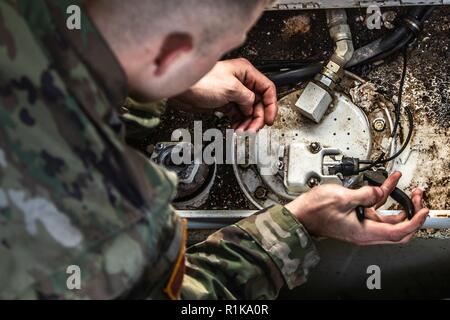 Un soldato con la Task Force Raider sostituisce una pompa di carburante in una M88 Recupero veicolo a Bemowo Piskie Area Formazione, Polonia, 11 ott. 2018. Task Force Raider è un avanzamento elemento distribuito dal Tennessee esercito Guardia Nazionale il 2° Stormo, 278th Armored reggimento di cavalleria, attaccato al gruppo di combattimento della Polonia e della NATO rafforzata presenza in avanti. EFP è una difesa e dissuasione contro le aggressioni ai membri Alliance in Europa Orientale. ( Foto Stock