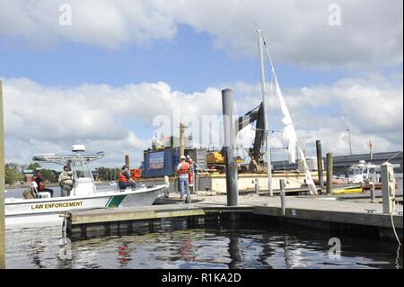 I membri dell'emergenza funzione di supporto-10 la risposta del team di supervisionare l'inquinamento-la mitigazione per rimuovere pericolose dal punto di vista ambientale da una barca a vela affondata in New Bern, N.C., domenica 7 ottobre, 2018. La Guardia Costiera ha collaborato con la Carolina del Nord la fauna selvatica delle risorse la Commissione e gli Stati Uniti Agenzia per la protezione ambientale sotto un comando unificato per effettuare il supporto di emergenza funzione-10 di missione che ha agito per ridurre al minimo i danni ambientali dopo l uragano Firenze. Foto Stock