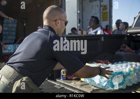 Blountstown, FL, 13 Ottobre 2018 - volontari i veicoli di carico con cibo e acqua in corrispondenza di un punto di distribuzione del sito durante l uragano Michael soccorsi. Punto di distribuzione o POD è dove il pubblico va a prelevare dei rifornimenti di emergenza a seguito di una catastrofe. Cpl. Jacklyn Farias /CAISE Foto Stock