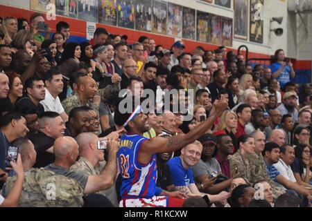 Figli adolescenti da una scuola di Kuwait e famiglie dall'Ambasciata americana in Kuwait uniti i membri del servizio in Harlem Globetrotter Exhibition Game al Camp Arfijan il 12 ottobre 2018. Gli studenti frequentano Access-Jahra presso il centro inglese, Jahra, finanziato dal governo degli STATI UNITI Dipartimento di Stato. L'inglese Microscholarship accesso programma fornisce una base di conoscenza della lingua inglese a luminoso, economicamente svantaggiate, gli studenti di età compresa tra 13 e 20 che possono avere anche la capacità di competere per i futuri scambi e di studiare negli Stati Uniti. "I bambini erano felici e non volevano lasciare", ha dichiarato Dan Foto Stock