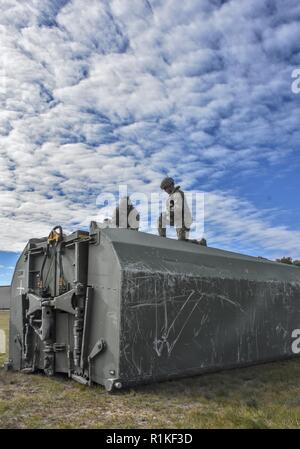 Soldati montare catene e cavi a una sezione a ponte come essi si preparano ad imbracare il carico loro Michigan Guardia Nazionale multi-ruolo di azienda a ponte da un campo di aviazione sicuro per un ostacolo di acqua nel Michigan del nord. Il combattimento pronto Michigan Guardia Nazionale è sempre pronti per il combattimento. Foto Stock