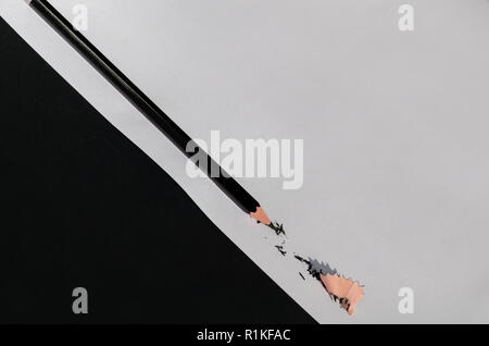 Matita nera con isolati di rasatura su Bianco e sfondo nero. La fotografia macro. Vista dall'alto. Foto Stock