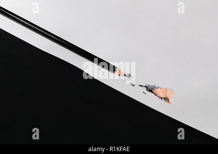 Matita nera con isolati di rasatura su Bianco e sfondo nero. La fotografia macro. Vista dall'alto. Foto Stock