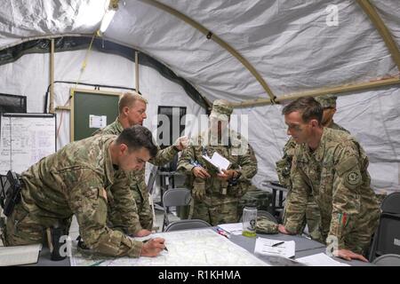 Il personale del reggimento di ufficiali e di membri del 2d della Cavalleria completa di leadership analisi della missione per esercitare Dragoon pronto alla multinazionale comune disponibilità centro in Hohenfels, Germania, 18 ottobre 2018. Col. Thomas M. trasformazione di Hough, commander, 2CR, ha fornito orientamenti per quanto riguarda il corso di azione di sviluppo per preparare meglio il suo personale per la fase successiva del militare il processo decisionale. Pronto Dragoon è un settimo Esercito di formazione comando/LED JMRC esercizio studiato per migliorare la prontezza e qualificare 2CR in terra unificata operazioni. Foto Stock