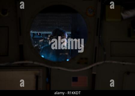 Stati Uniti Air Force Capt. Tory Nicholson, XXI Airlift Squadron C-17 Globemaster III pilota, va oltre la prossima missione di formazione con gli altri membri di equipaggio in una C-17 a Travis Air Force Base in California, Ottobre 17, 2018. Travis aviatori condurre gli eventi di formazione per rimanere aggiornati e di essere preparati per le future operazioni di mobilità. Foto Stock