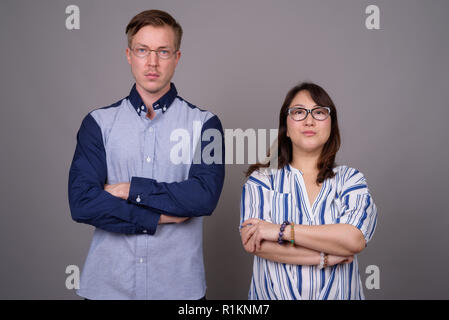 Giovane imprenditore bello e maturo imprenditrice asiatici contro Foto Stock