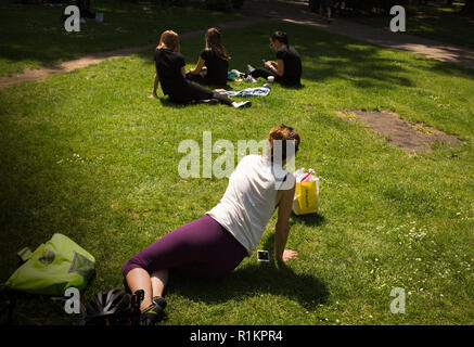 Donna e di altre persone aventi una pausa pranzo in Cavendish Square, Londra Foto Stock