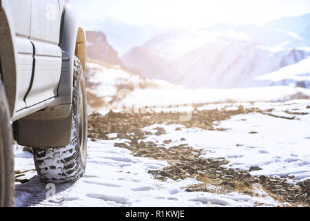 Fuoristrada 4x4 auto ruota sulla superficie della neve. Pneumatici invernali concept Foto Stock