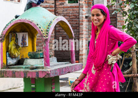 Donna sorridente in un sari rosso. Villaggio indiano nella provincia. Himachal Pradesh Giugno 2018 Foto Stock