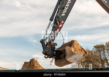 Escavatore scarica la sua sabbia nel corpo di un carrello Foto Stock