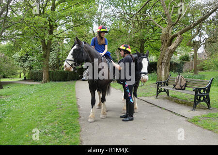 Ragazza scuola di prepararsi ad una guida dalla scuola a cavallo con la madre in Shropshire Regno Unito Foto Stock