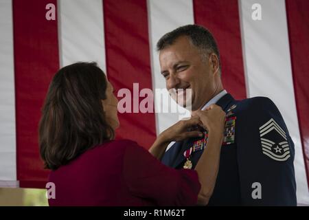 Master Chief Sgt. Michael West, a destra una tattica speciale controller di combattimento con il ventiquattresimo Special Operations Wing, riceve il suo pensionamento il perno dalla sua moglie Paola West, durante una cerimonia di pensionamento a Hurlburt Field, Florida, Ottobre 19, 2018. Per 30 anni, West faceva parte di una altamente addestrati speciali operazioni vigore che integra la forza aerea in operazioni speciali " Schema di massa di manovra. Foto Stock