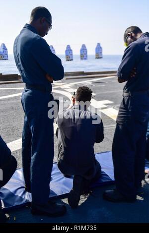 Mare Mediterraneo (ott. 19, 2018) - marinaio Kamoy Williamson incendi un M16 fucile mentre Fire Controlman 3rd Class Thomas Williams, a sinistra e di artigliare il compagno del marinaio Dominique Dunn coach lui durante un'esercitazione a fuoco a bordo della Arleigh Burke-class guidato-missile destroyer USS Ross (DDG 71) nel Mare Mediterraneo, Ottobre 19, 2018. Ross, distribuita a Rota, Spagna, è il suo settimo patrol NEGLI STATI UNITI Sesta flotta area di operazioni a sostegno degli Stati Uniti per gli interessi di sicurezza nazionali in Europa e in Africa. Foto Stock