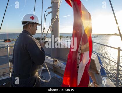 MAYPORT, Fla. (ott. 21, 2018) - Ospedale Corpsman Daniel Gonzalez turni colori dopo l'ormeggio a Mayport, Florida, sul dock anfibio sbarco nave USS Fort McHenry (LSD 43) come parte del Carrier Strike gruppo (CSG) composito 4 unità di addestramento esercizio (COMPTUEX). COMPTUEX è la pre-finale esercizio di distribuzione che certifica il combinato anfibio Kearsarge pronto gruppo (ARG) e 22 Marine Expeditionary Unit (MEU) per la capacità di condurre operazioni militari in mare e proiettare potenza a terra attraverso una pianificazione comune e esecuzione di impegnativo e scenari realistici. CSG 4 guide, trai Foto Stock