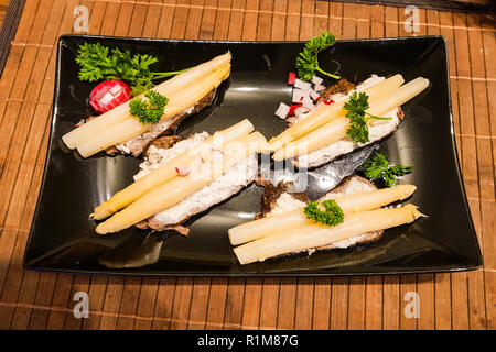 A basso contenuto calorico cibo. Asparagi sul pane nero con Ravanelli e quark fresco Foto Stock