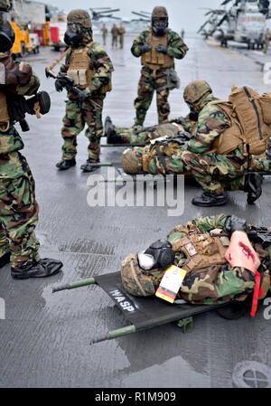 Mar Cinese Orientale (ott. 22, 2018) Marinai e marines, assegnato al trentunesimo Marine Expeditionary Unit (MEU), prendere parte a un chimici, biologici, radiologici e nucleari (CBRN) massa casualty seminatrice sul ponte di volo dell'assalto anfibio nave USS Wasp (LHD 1). Wasp, ammiraglia di Vespa Anfibia Gruppo pronto, con avviato 31 MEU, è operativo nell'Indo-Pacifico regione per migliorare l'interoperabilità con i partner e servire come una pronta risposta in vigore per qualsiasi tipo di emergenza. Foto Stock