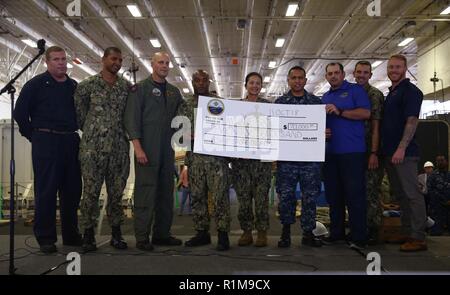 NEWPORT NEWS, Va. (ott. 11, 2018) membri della USS Gerald Ford (CVN 78) dipartimento di alimentazione presente un controllo per il morale, benessere e dipartimento di ricreazione durante un tutte le mani nella chiamata della nave di hangar bay. Ford è attualmente in fase di post-shakedown disponibilità presso Huntington Ingalls Industries-Newport News la costruzione navale. Foto Stock