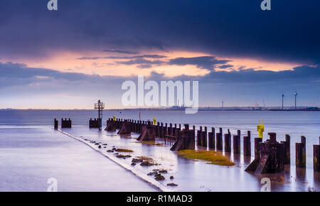 I resti del vecchio molo in legno a Portishead che sfocia nel Canale di Bristol con la costa del Galles in background fotografati a sunrise. Foto Stock