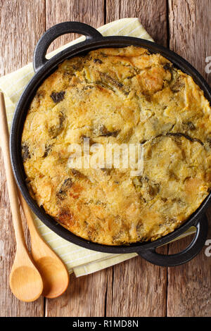 In casa inglese Bubble & Squeak di cosse al forno purè di patate con cavoli e cavolini di Bruxelles in un tegame sul tavolo. Verticale in alto vista da sopra Foto Stock