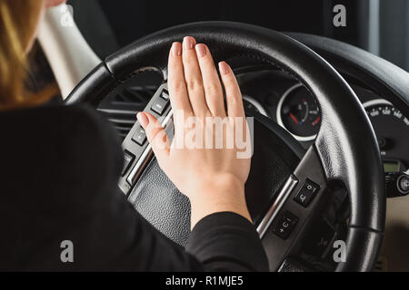 Ritagliato colpo di donna clacson avvisatore acustico mentre si guida auto Foto Stock