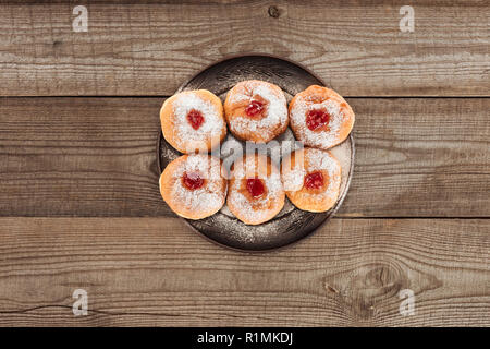 Vista dall'alto di ciambelle dolci sul piano portapaziente in legno, celebrazione hannukah concept Foto Stock