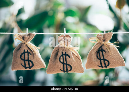 Sacco sacchi con il simbolo del dollaro appeso sulla corda Foto Stock